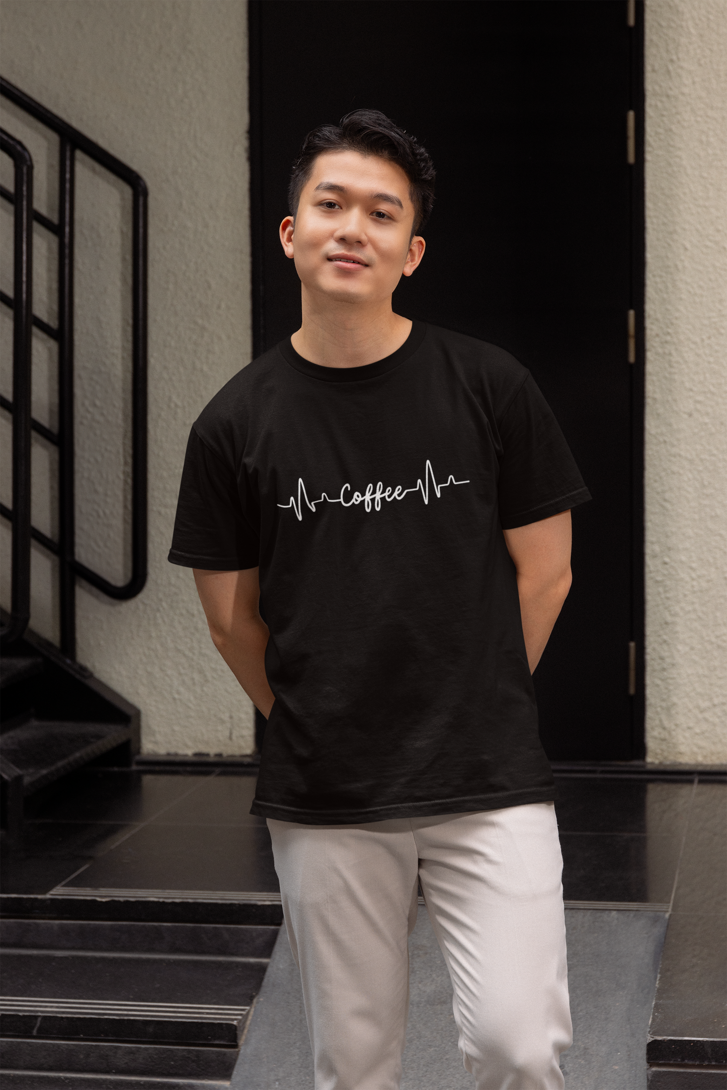 Person wearing a black t-shirt with a design, standing in an indoor setting.